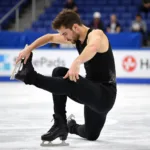 Male figure skater practicing a sit spin in black figure skating pants