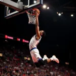 A basketball player executing a powerful dunk during a game