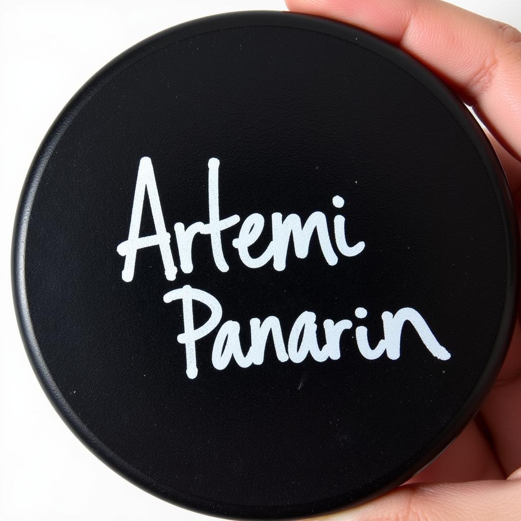 Close-up view of a signed Artemi Panarin puck showing details of signature and puck condition.