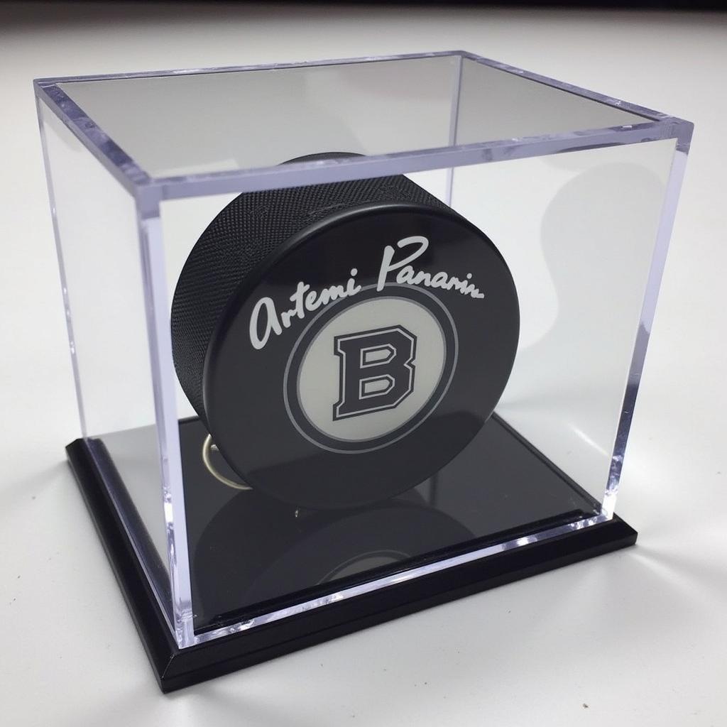 An Artemi Panarin signed puck displayed in a protective acrylic case.