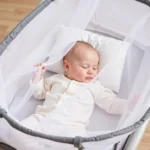 Baby sleeping soundly in pack n play with bug net