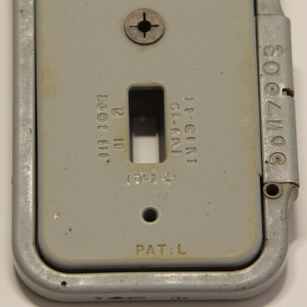 Close-up of markings on an antique light switch cover to illustrate how to identify age and manufacturer.